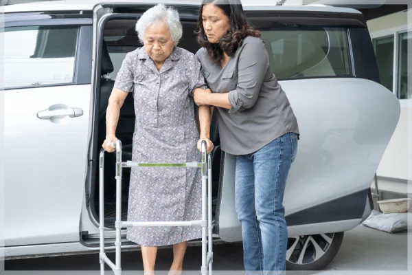 Reliable-Transportation-Caregiver-helping-elderly-woman-with-a-walker-exit-a-van-MeetCaregivers